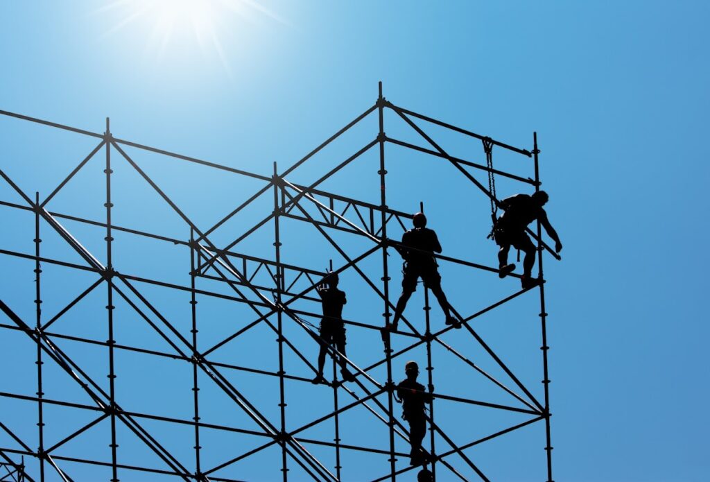Construction workers on a scaffold, wearing harnesses
